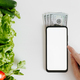 Human hand touching smartphone mockup, eco vegetables and money. Mobile phone white blank display  - PhotoDune Item for Sale