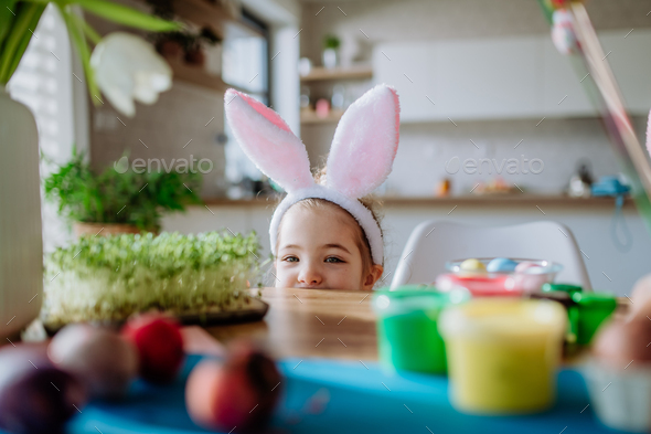 Little girl with bunny ears enjoying easter time in home. - Stock Photo - Images