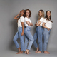 Full length of four young caucasian women wearing blue jeans and white tshirt on grey background - PhotoDune Item for Sale