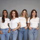 Four young caucasian women wearing blue jeans and white tshirt on grey background - PhotoDune Item for Sale