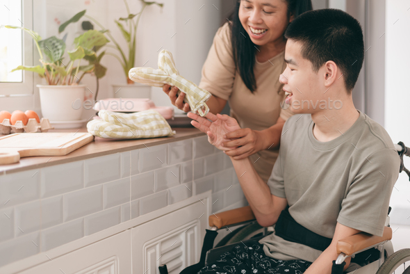 Concept of activities in everyday life by parents of happy teenage boy with disability on wheelchair - Stock Photo - Images