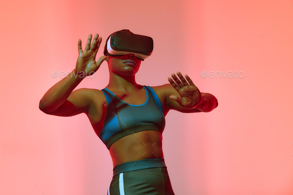 African american woman streamer playing video game using virtual reality glasses at gaming room