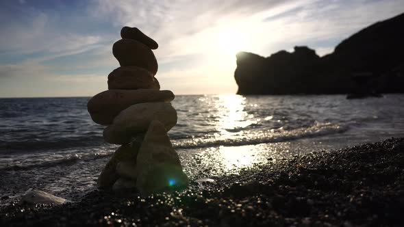 Pyramid Stones on the Seashore on a Sunny Day on the Blue Sea Background alt