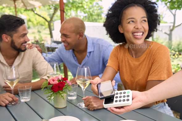 Woman Paying Bill At Outdoor Bar Or Restaurant Using Contactless App On Mobile Phone - Stock Photo - Images