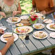 Close Up Of Friends Enjoying Outdoor Meal And Wine On Visit To Vineyard Restaurant - PhotoDune Item for Sale