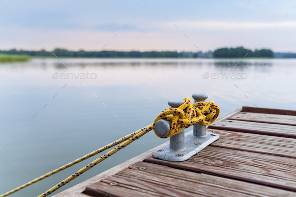 Bollard on the pier with lake in the background - Stock Photo - Images