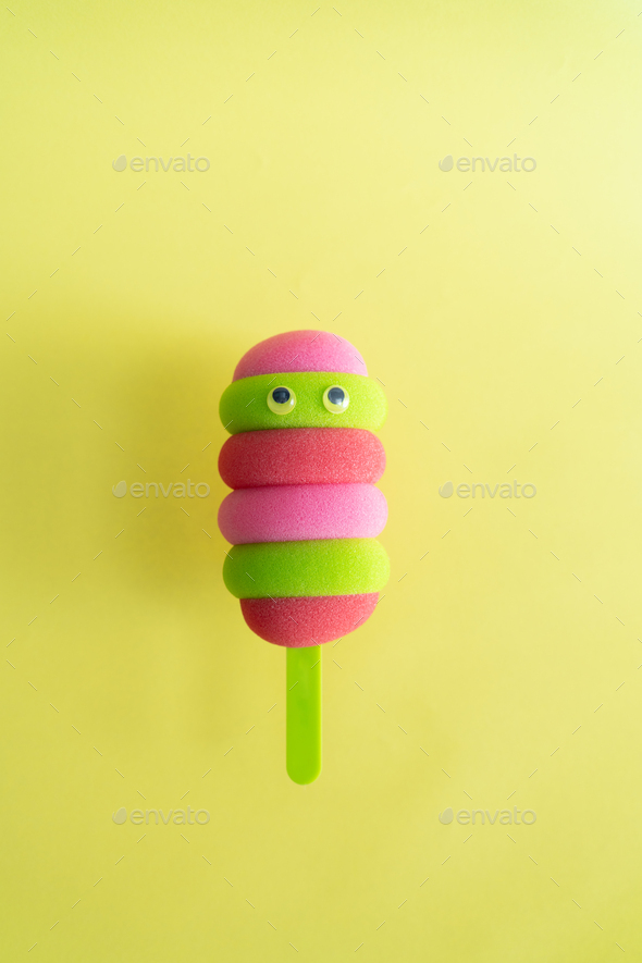 Colored ice cream popsicle on a pastel yellow background. Minimal summer concept - Stock Photo - Images