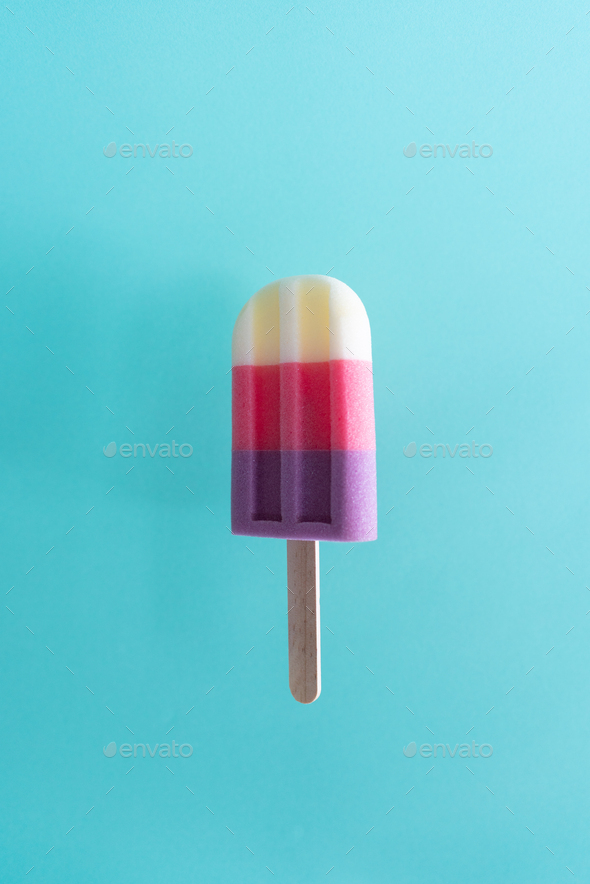 Colored ice cream popsicle on a pastel light blue background. Minimal summer concept - Stock Photo - Images