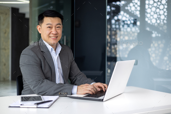 Successful mature asian boss working on laptop, portrait of adult senior investor at computer at - Stock Photo - Images