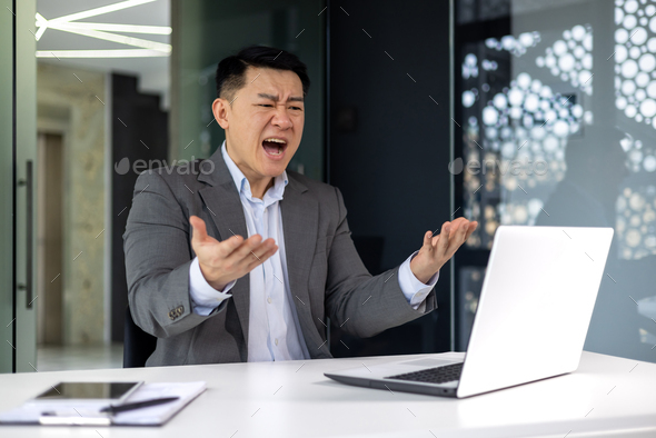 Angry boss working at work, senior experienced businessman in business suit shouting at computer - Stock Photo - Images