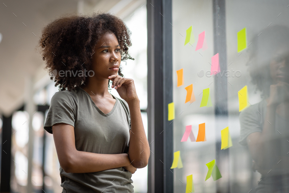 A black American african business woman in afro hairstyle planning in meeting at office and use post
