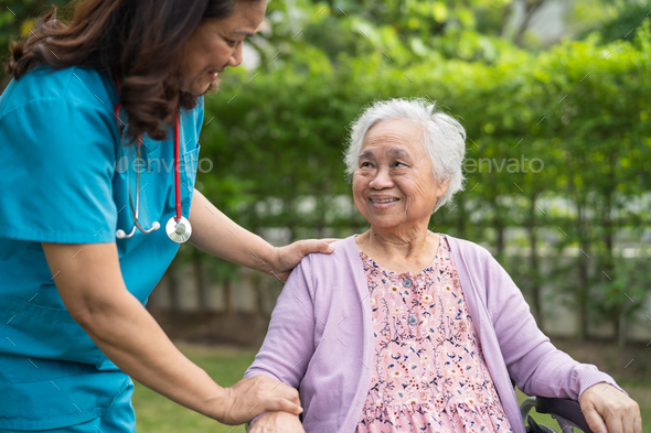 Doctor caregiver help and care Asian senior woman patient sitting on wheelchair at hospital. - Stock Photo - Images