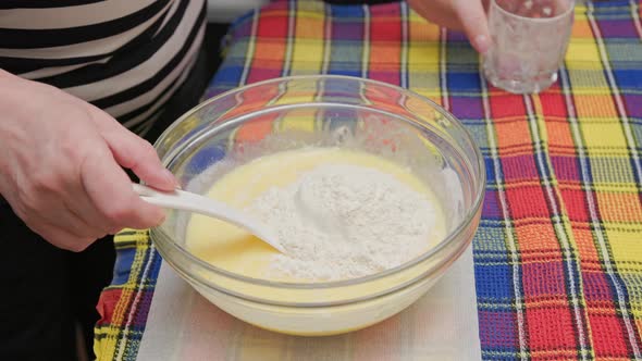 Senior Caucasian Woman Adding Flour to the Bowl with Liquid Sweet Dough