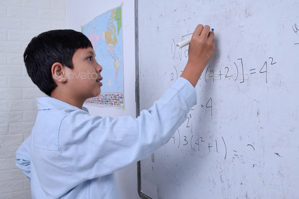 Asian boy writing solution of square root on white board