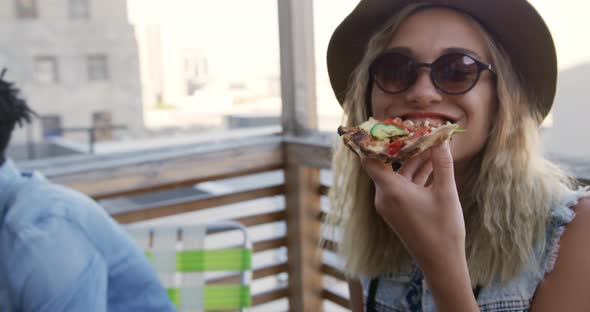 Young adult friends hanging out on a rooftop alt