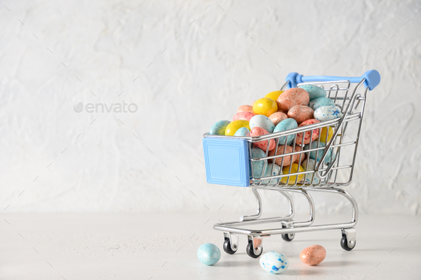 Easter composition with colorful chocolate eggs in shopping cart. Copy space. - Stock Photo - Images