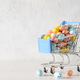 Easter composition with colorful chocolate eggs in shopping cart. Copy space. - PhotoDune Item for Sale