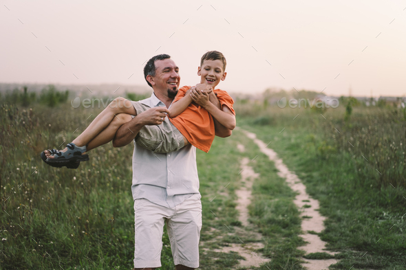 Happy Fathers day. Father with son are walking in the field. - Stock Photo - Images