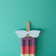 Colored popsicle with glasses on mint background. Minimal summer concept. - PhotoDune Item for Sale