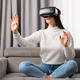Girl in VR goggles playing games and touching something in the air. - PhotoDune Item for Sale