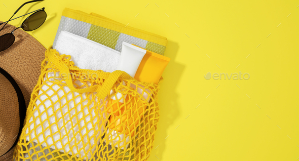 String bag with things for beach towel, sunscreens, Skin Cancer Awareness Month Concept