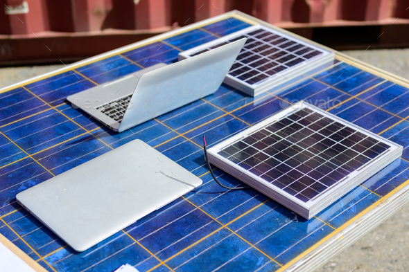 Laptop and solar panels at industrial container yard factory