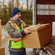 Mid adult driver loading packages into delivery van. - PhotoDune Item for Sale