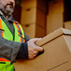 Close up of courier unloading cardboard boxes out of delivery van. - PhotoDune Item for Sale