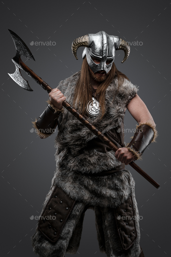 Violent viking with huge axe against grey background Stock Photo by
