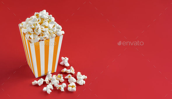Yellow White Striped Carton Bucket With Tasty Cheese Popcorn, Isolated On Red Background - Stock Photo - Images