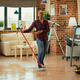 Happy woman dancing in living room and using mop to clean floors - PhotoDune Item for Sale