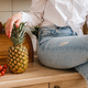 a close-up of a housewife in a white shirt and jeans is sitting on a table and fruits - PhotoDune Item for Sale