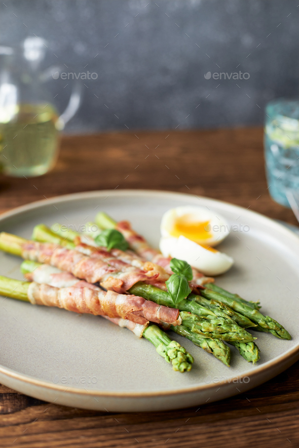 Fresh asparagus wrapped in bacon and grilled, served with egg benedict