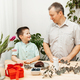 Dad and son prepare a gift for mother&#39;s day. Decorate the cake with berries.  - PhotoDune Item for Sale
