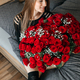A beautiful girl is sitting on a bed in the bedroom with a huge bouquet of scarlet roses.  - PhotoDune Item for Sale
