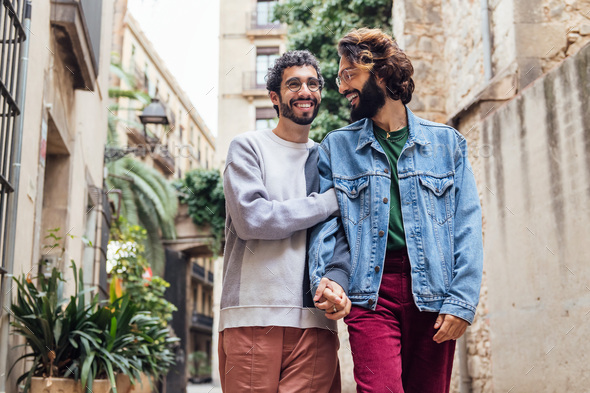 male couple walking embraced and laughing happy - Stock Photo - Images