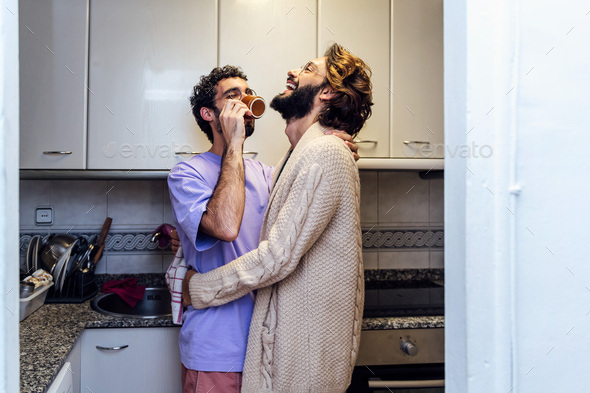 male couple laughing happy with a morning coffee - Stock Photo - Images
