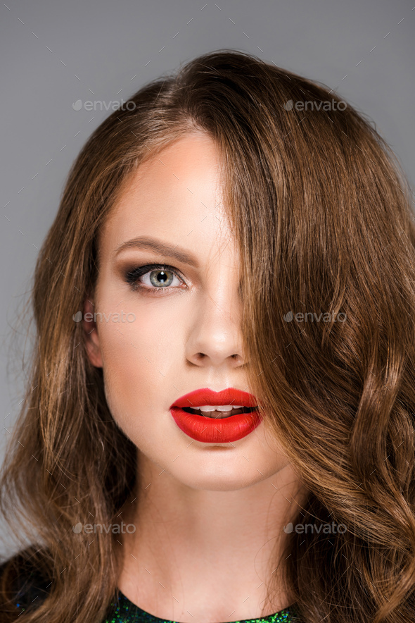 portrait of attractive young woman with red lipstick on lips looking at camera - Stock Photo - Images