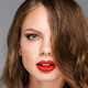 portrait of attractive young woman with red lipstick on lips looking at camera - PhotoDune Item for Sale