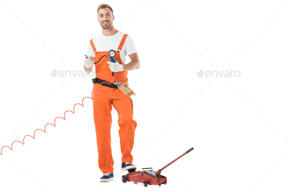 handsome auto mechanic in orange uniform holding gauge pressure isolated on white