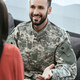 smiling soldier talking at psychiatrist and gesturing while sitting on couch during therapy session - PhotoDune Item for Sale