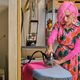 Tailor with pink hair and colorfull clothes ironing fabric. - PhotoDune Item for Sale