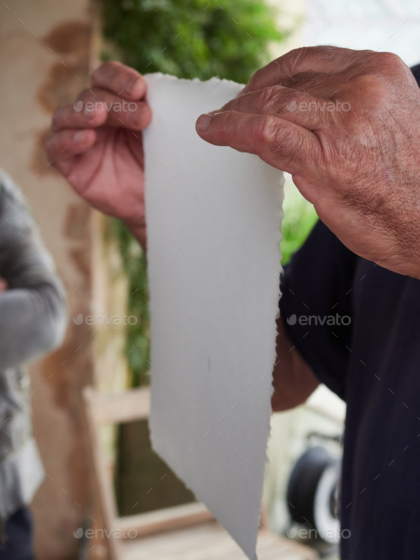 artisan\'s hands holding handmade sheets of paper. Old traditional paper production process.