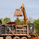 An excavator is loading earth into dump truck on construction site - PhotoDune Item for Sale