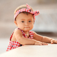 Lifestyle portrait of infant baby girl standing and holding on to a bench on 4th of July day - PhotoDune Item for Sale