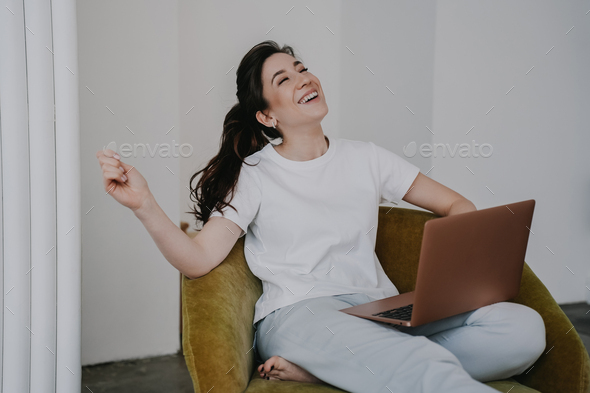 Happy young woman celebrating accomplished online courses, satisfied by knowledge , possibilities