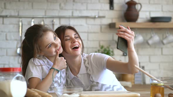 Two Sisters Having Fun at The Kitchen and Taking Selfies on The Smartphone