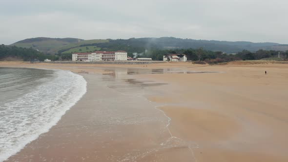 Aerial view; Plentzia northern coastline in Spain; beautiful beach with waves in cloudy day
