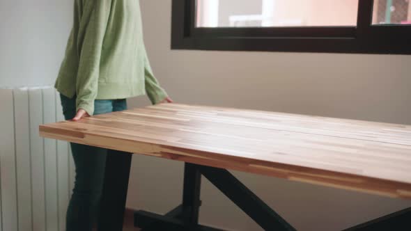 Woman Lifted Wooden Table By The Window Of House. - close up alt
