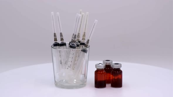 Vaccine bottle with red solution with syringe alt